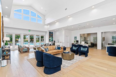 A living room with a blue couch and a wooden floor.